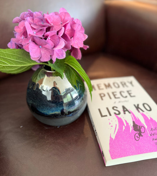 Here’s Looking At You vase styled with a novel by Lisa Ko and hydrangeas