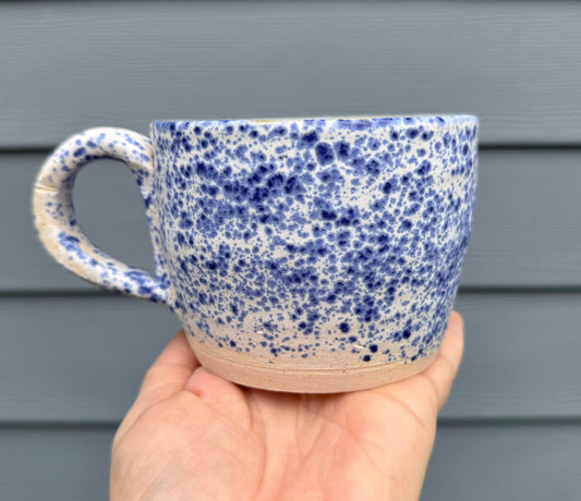 Close-up view of speckled blue glaze on handmade ceramic mug